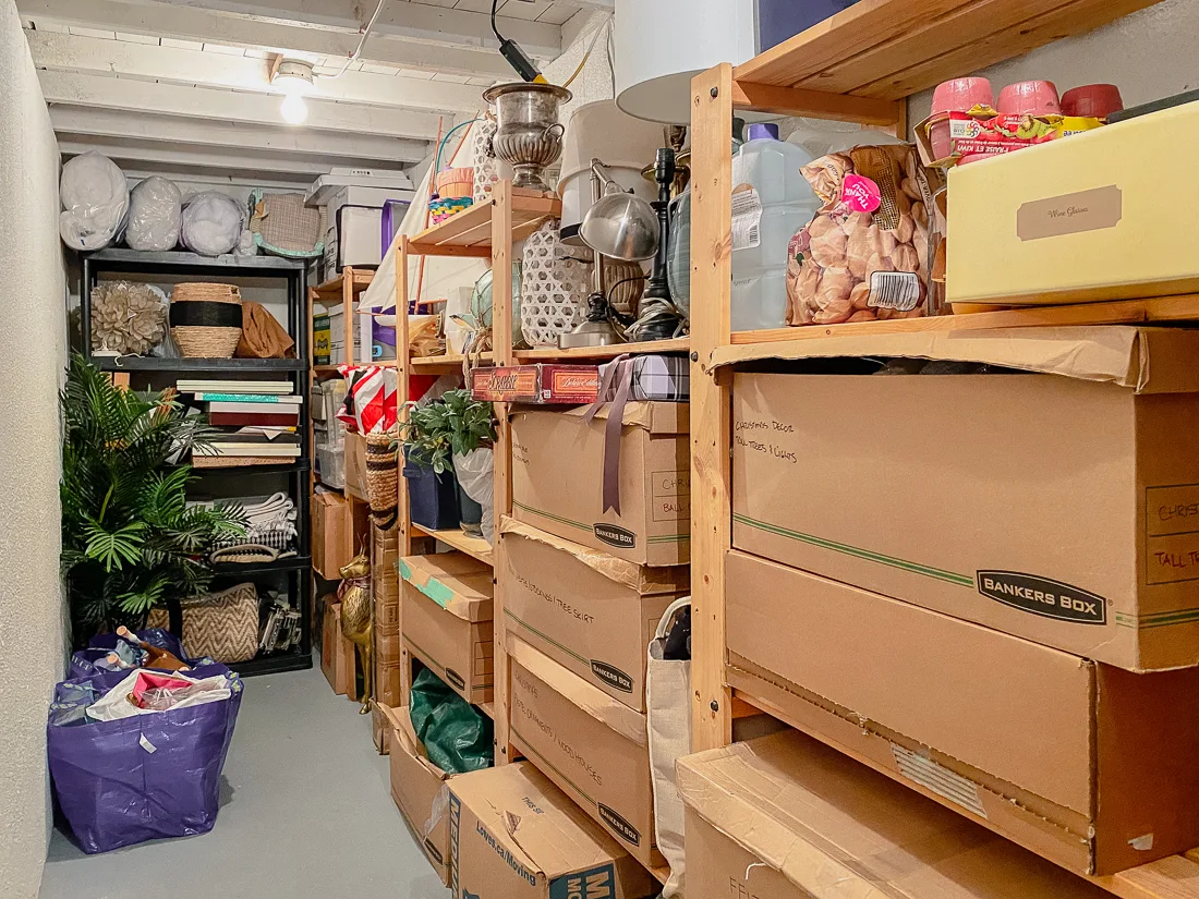 A basement storage area with several cardboard boxes stacked along a wall and a few items stored on the floor