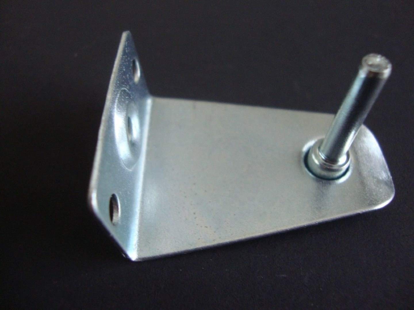 A bottom rail hold-down bracket installed on a window sill with the shade lowered into place