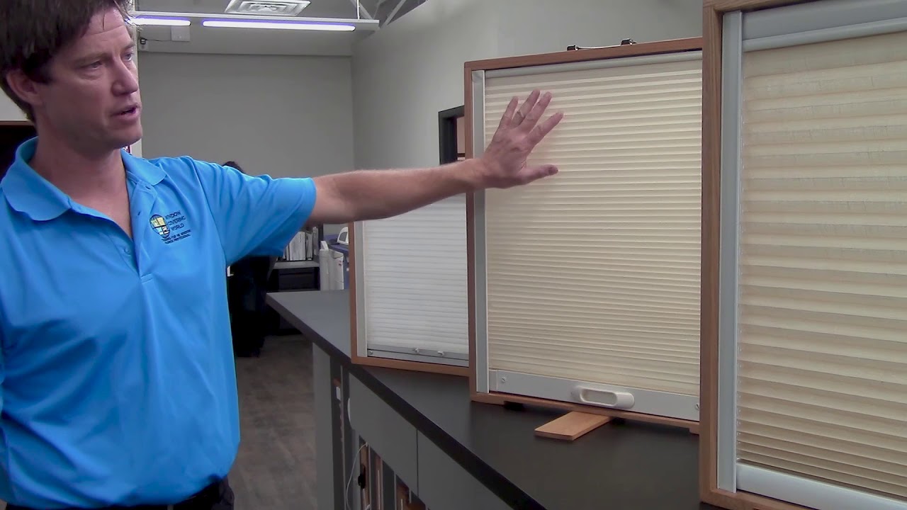A close-up of blackout cellular shade side channels installed on a window frame with the shade lowered inside the channels