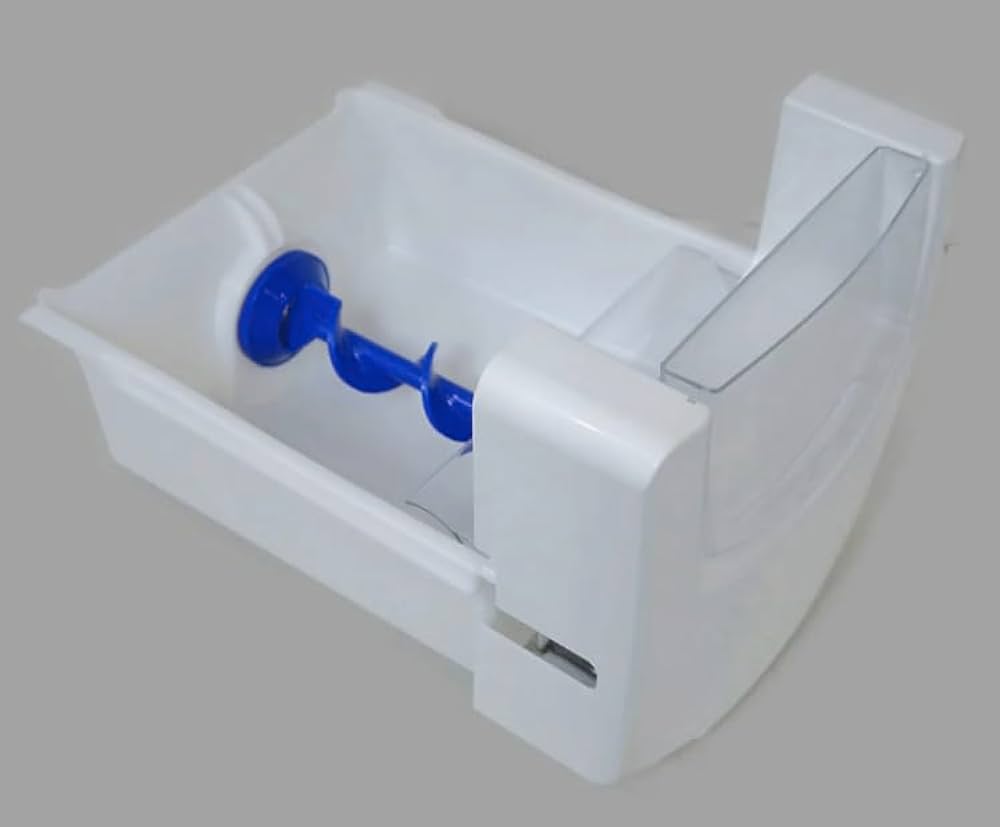 A close-up photo of a plastic refrigerator ice bin on a kitchen counter with the auger mechanism visible and a person inspecting it with their hands
