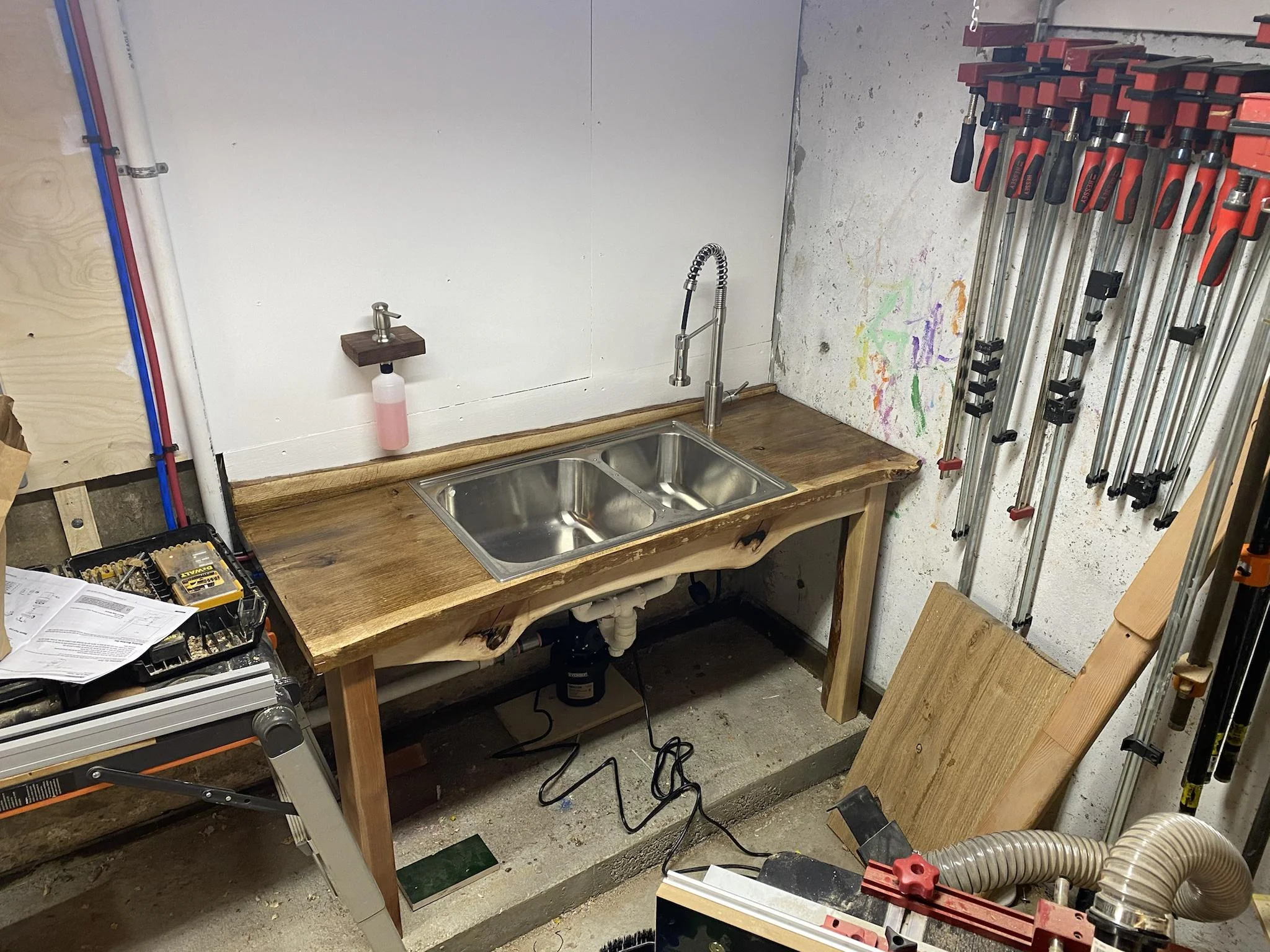 A deep plastic utility sink with a mesh strainer catching gritty debris from a bucket rinse
