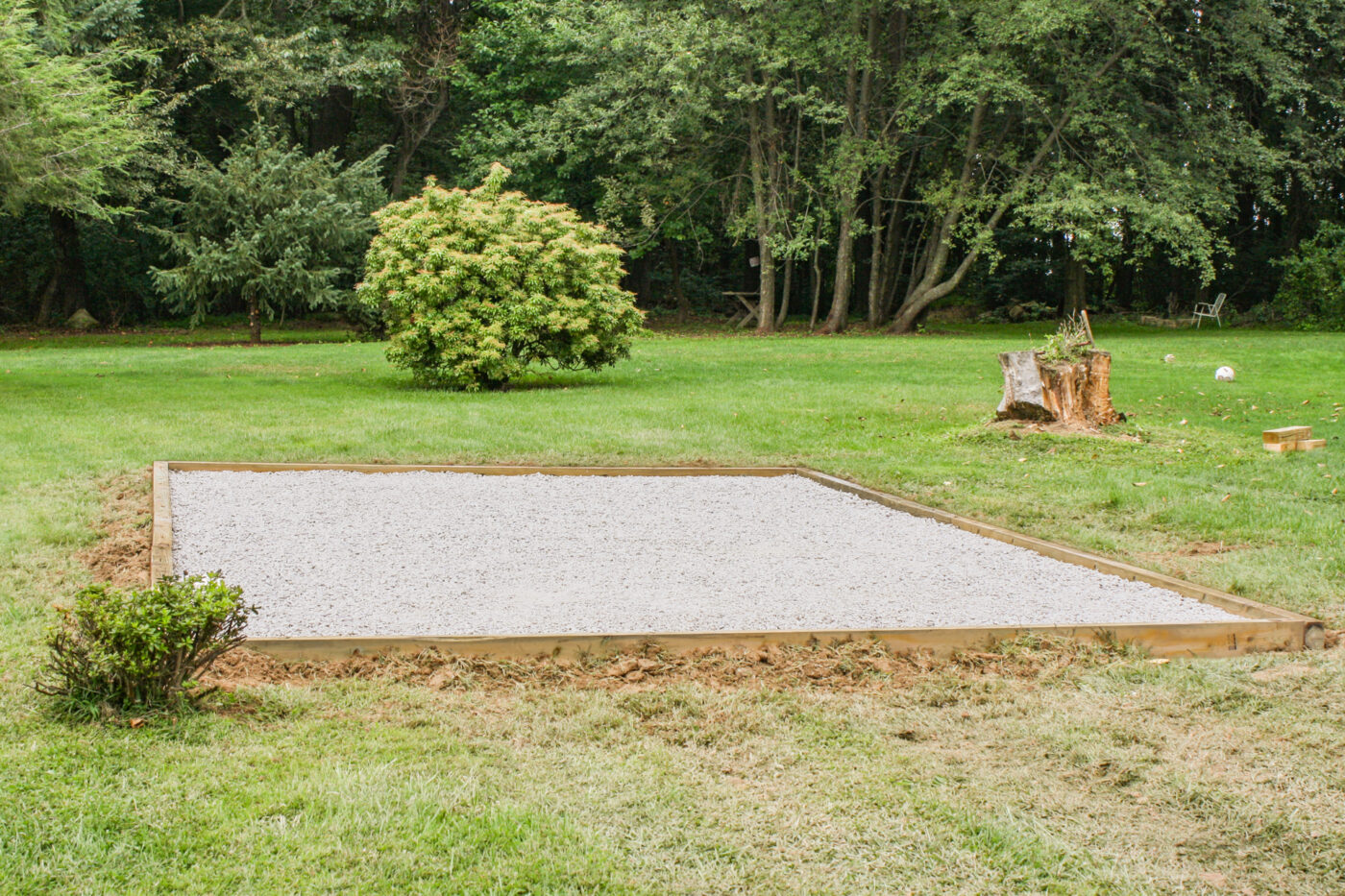 A gravel strip border along the base of a house foundation with no grass touching the siding