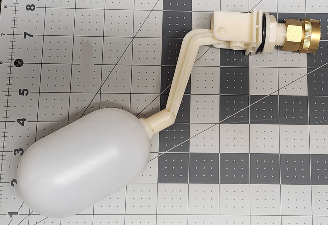 A person adjusting the float valve inside an evaporative cooler water pan with a small wrench