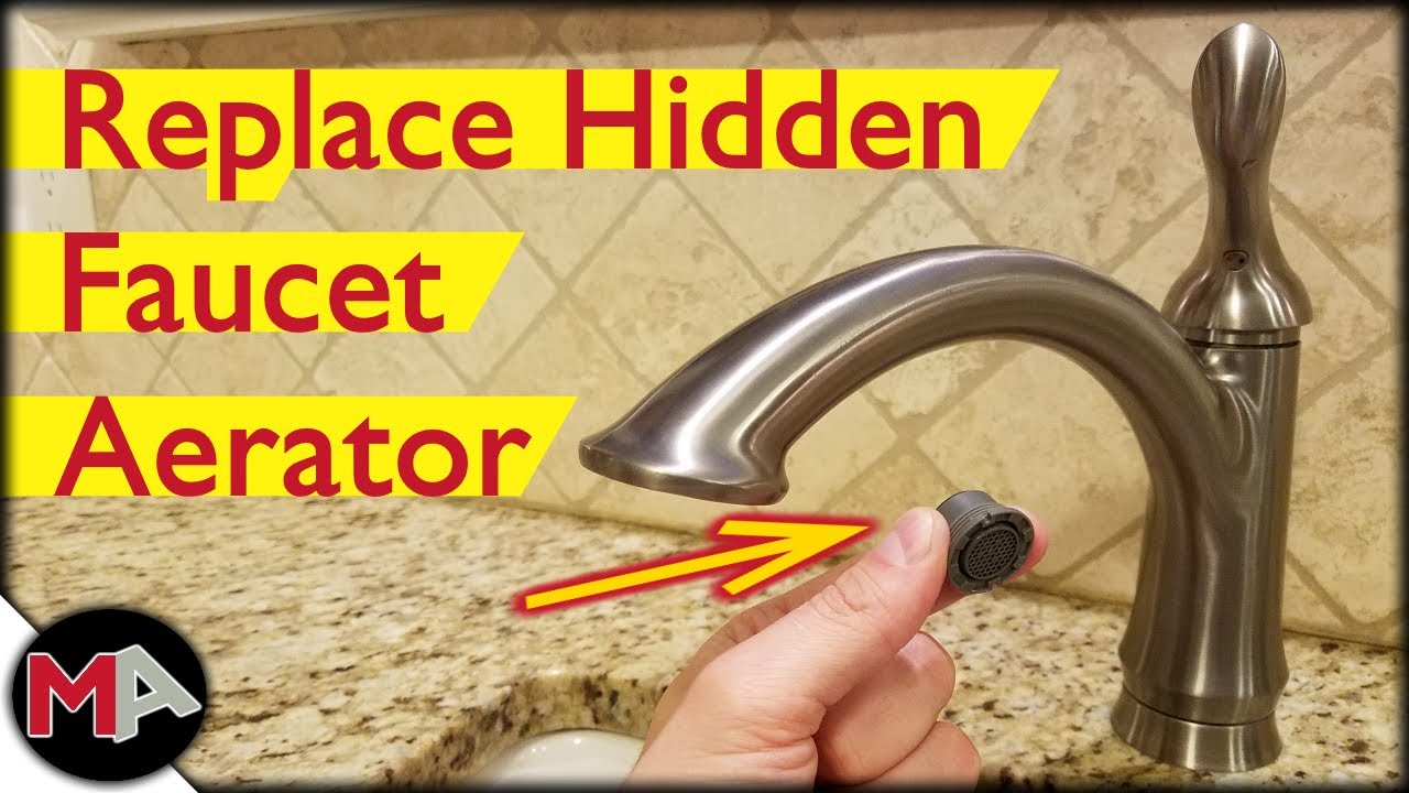 A real close-up photo of a hand using a small plastic aerator key to remove a recessed faucet aerator from the tip of a modern bathroom faucet