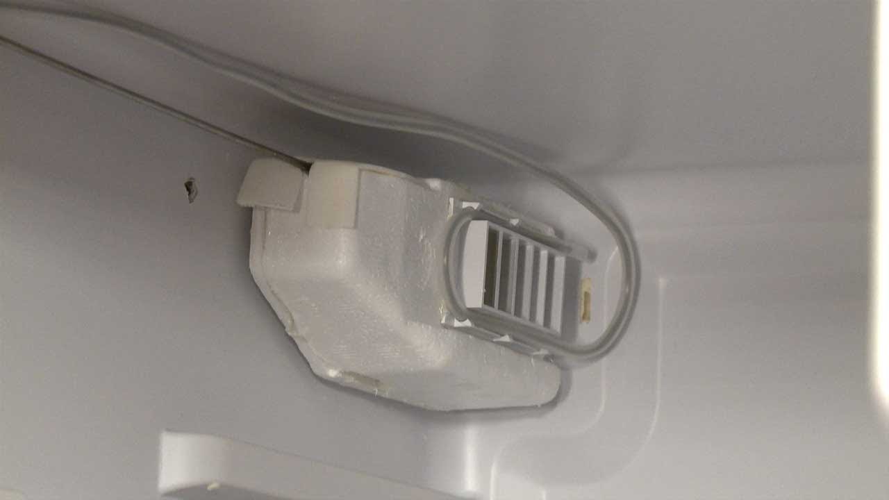 A real close-up photo of a refrigerator fresh-food compartment upper vent area where the air damper assembly is located