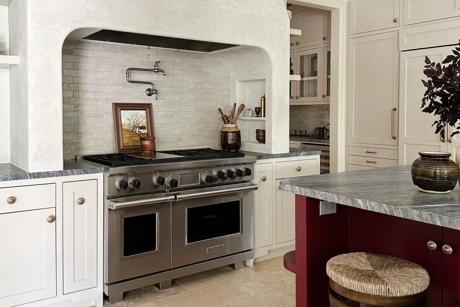 A real home interior showing a kitchen range hood running while a wood-burning fireplace is visible in the adjacent living area, evening indoor lighting
