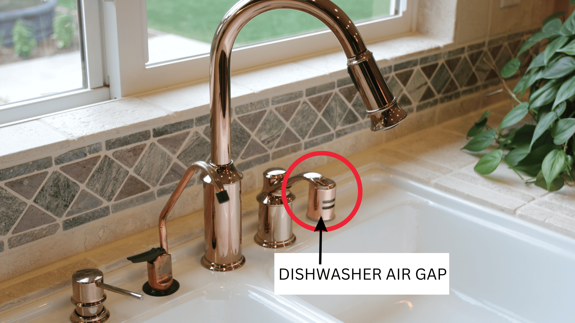 A real kitchen sink with a chrome dishwasher air gap cap on the countertop next to the faucet, with water droplets visible around the air gap