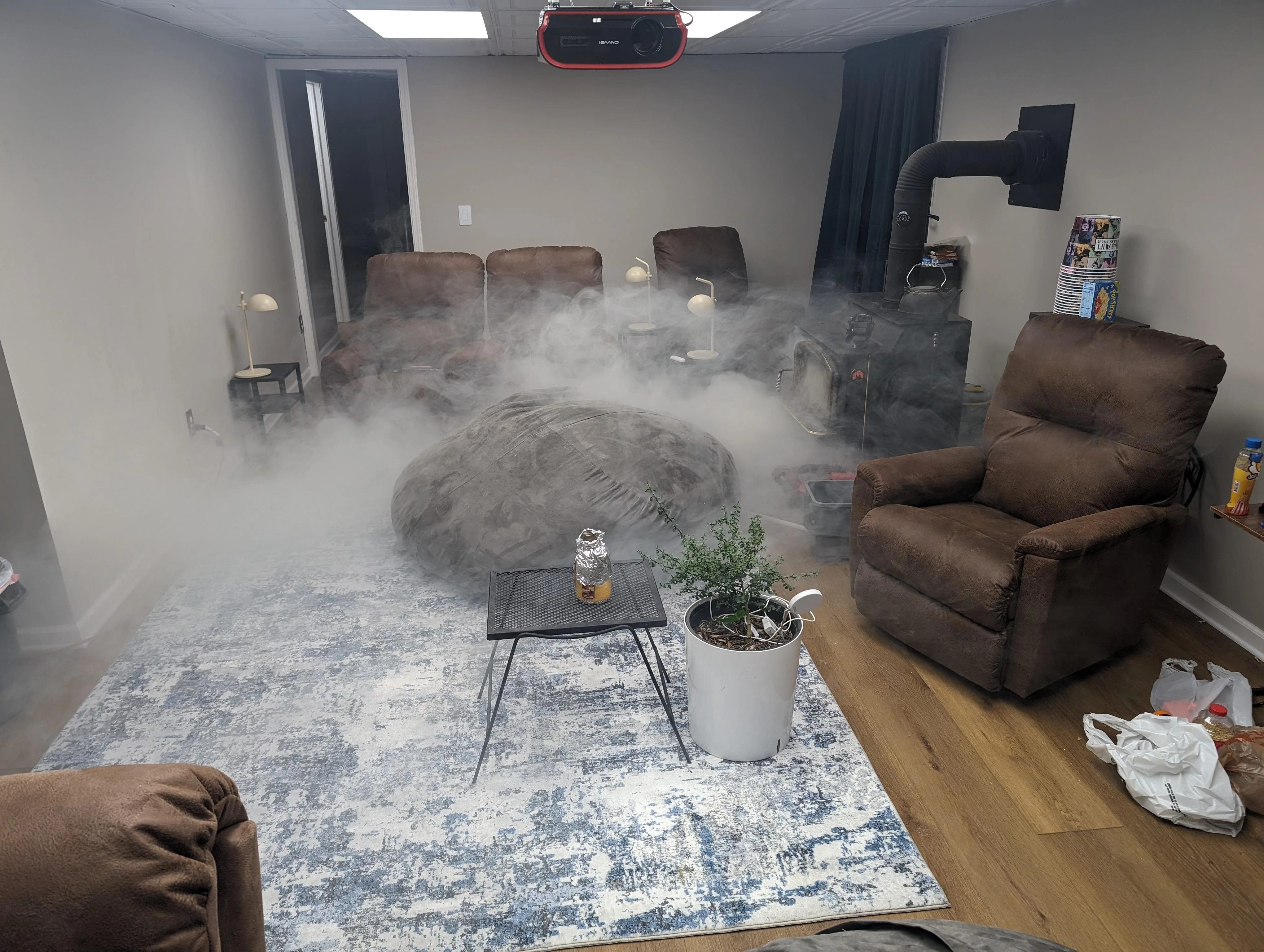 A real living room with a wood-burning fireplace where light gray smoke is rolling out of the firebox opening into the room, natural indoor lighting, realistic home photo