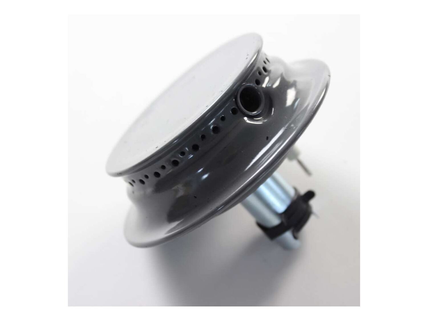 A sealed gas burner with the grate removed and the burner cap lifted off, showing the cap and burner head surfaces that must sit flat for a stable flame