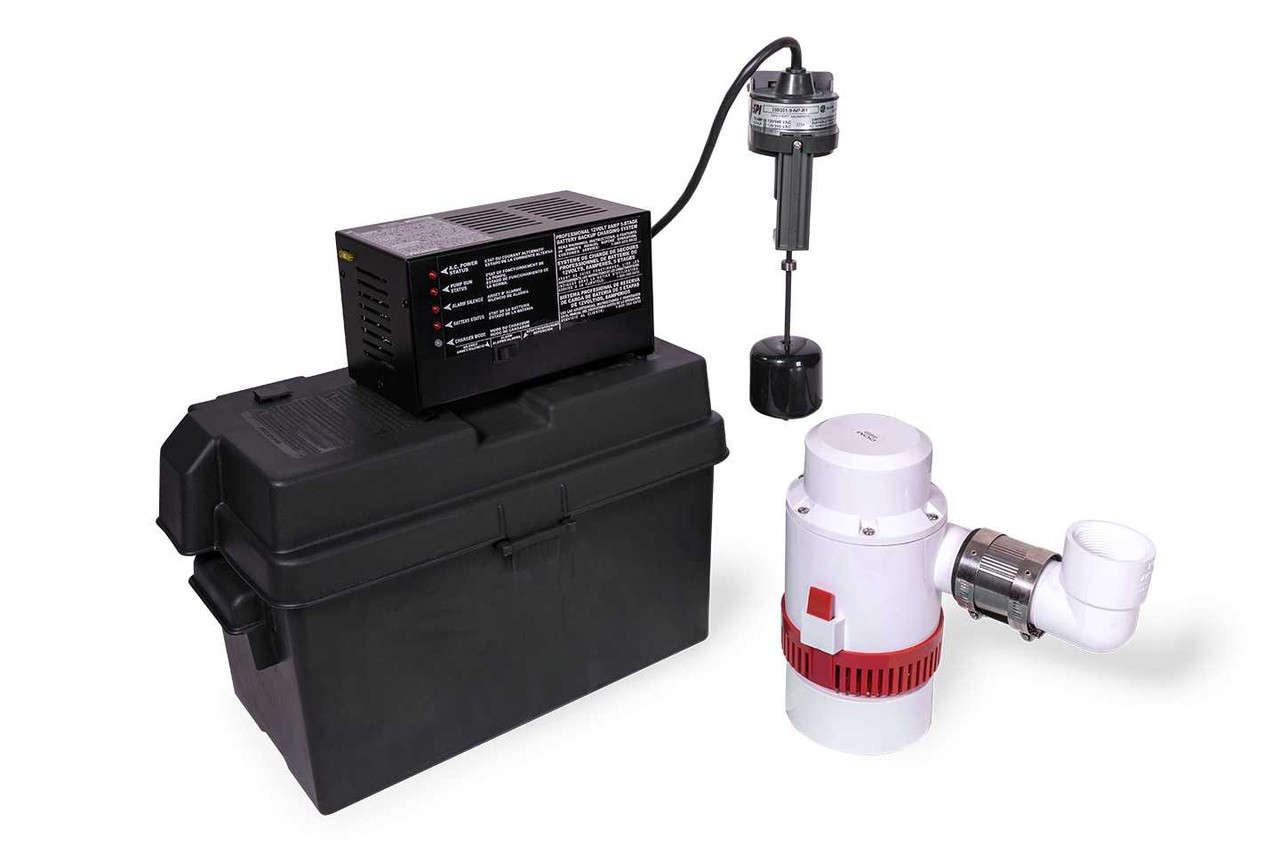A sump pump battery backup controller on a basement wall with indicator lights illuminated next to a sealed battery on the floor