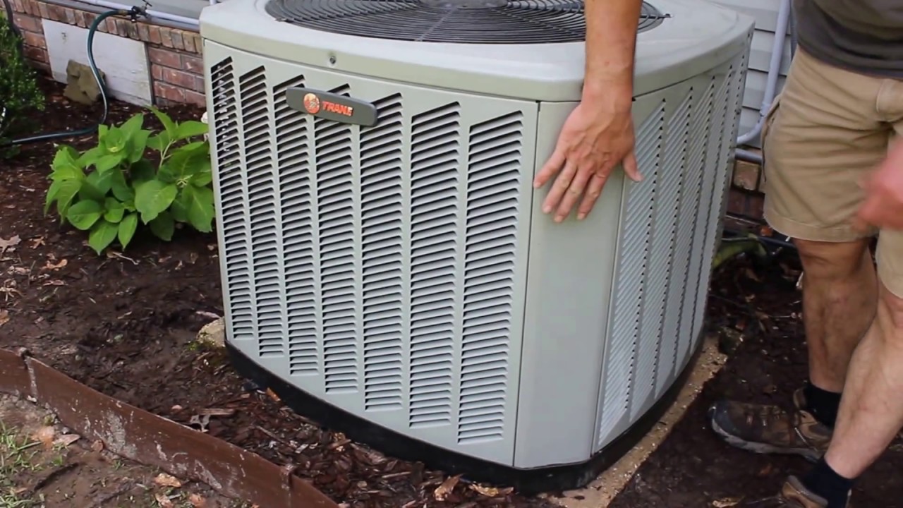 An outdoor air conditioner condenser unit shown for service reference, with an access panel removed