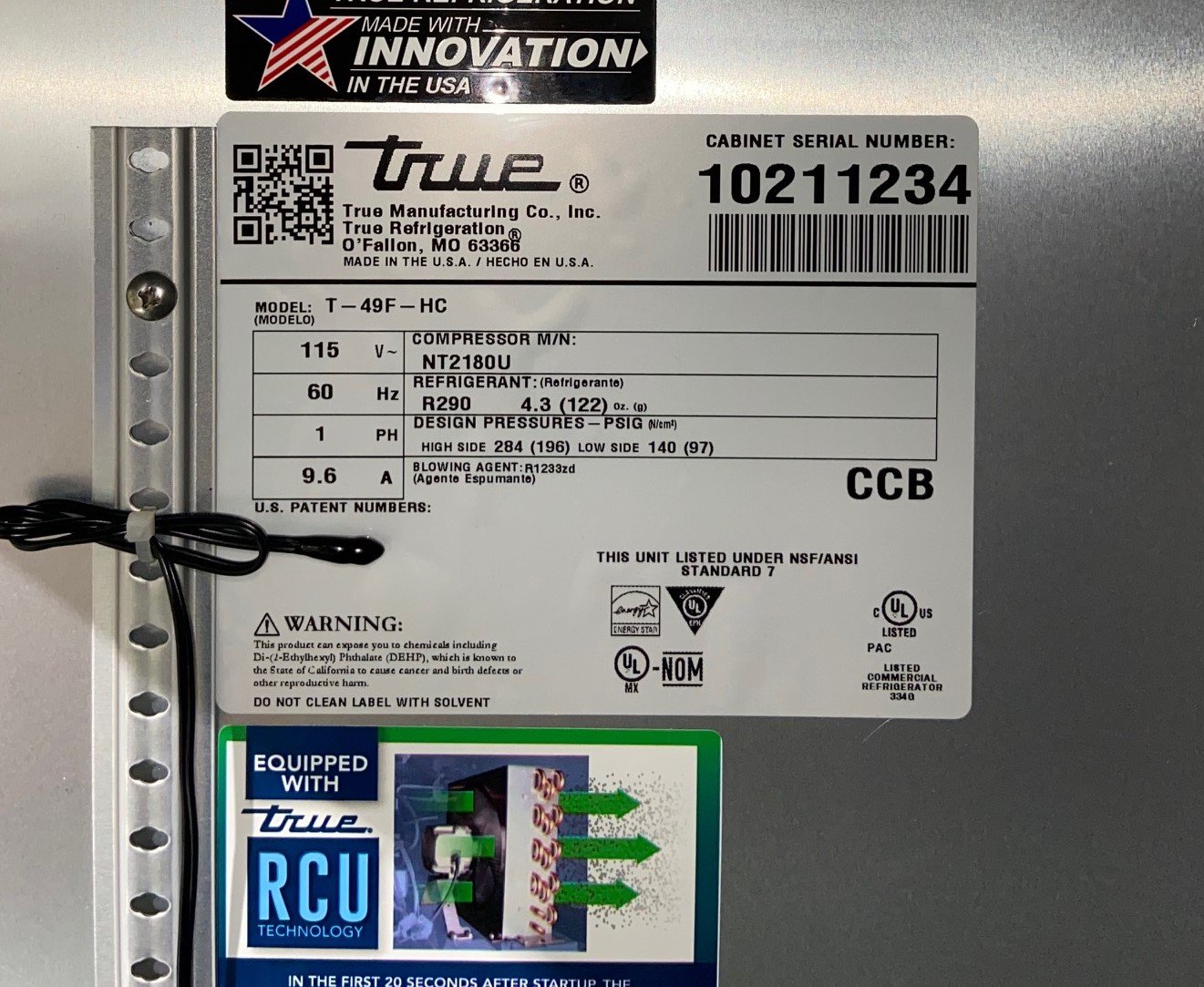 Close-up of a freezer model and serial number label sticker located near the lid opening on a chest freezer
