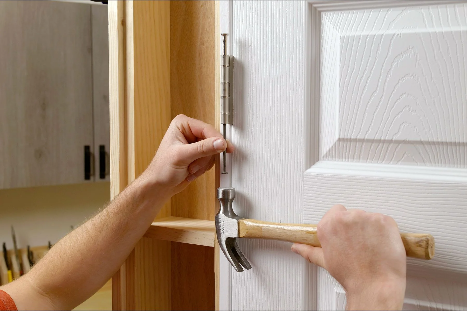 Door hinge with the hinge pin partially removed and resting on a rag