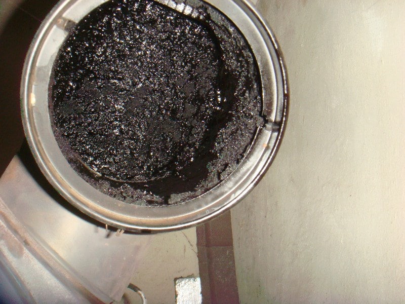 Furnace burner compartment with visible soot staining near the burner opening