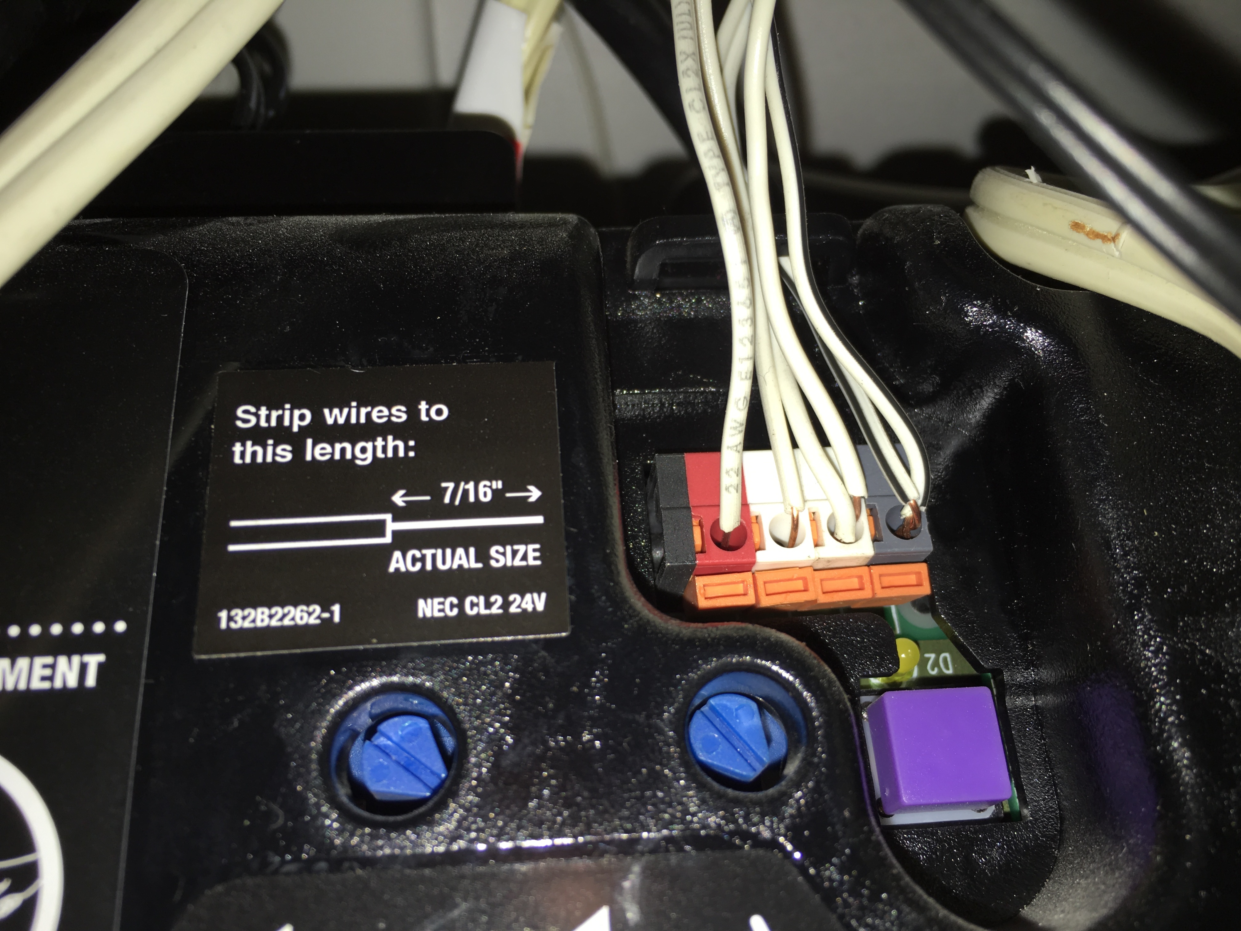 Garage door opener motor unit terminals with the thin wall-control wires disconnected and separated.