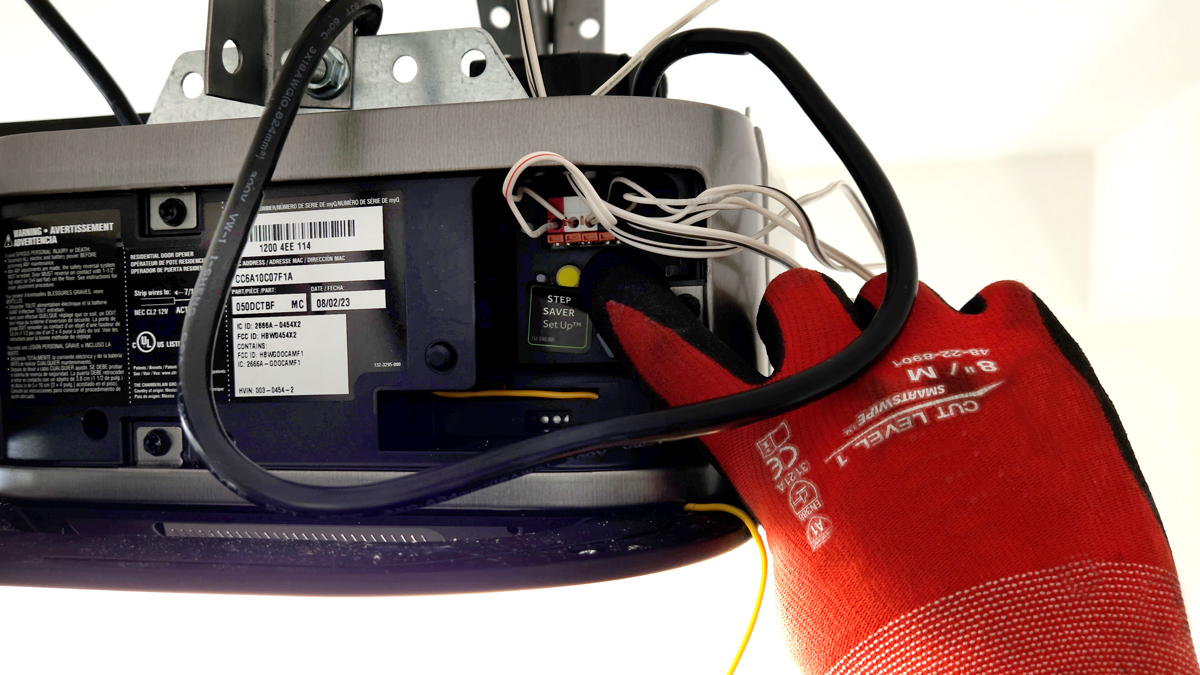 Garage door opener motor unit with the learn button and indicator light visible.