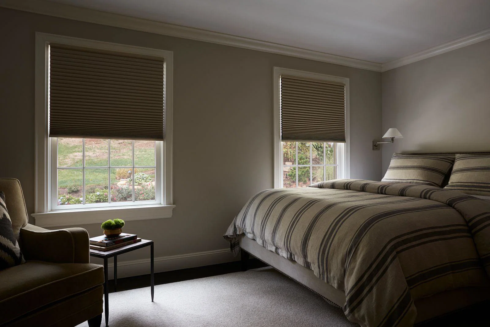 Light leaking along the side edge of a blackout cellular shade near a window frame, showing the typical narrow gap