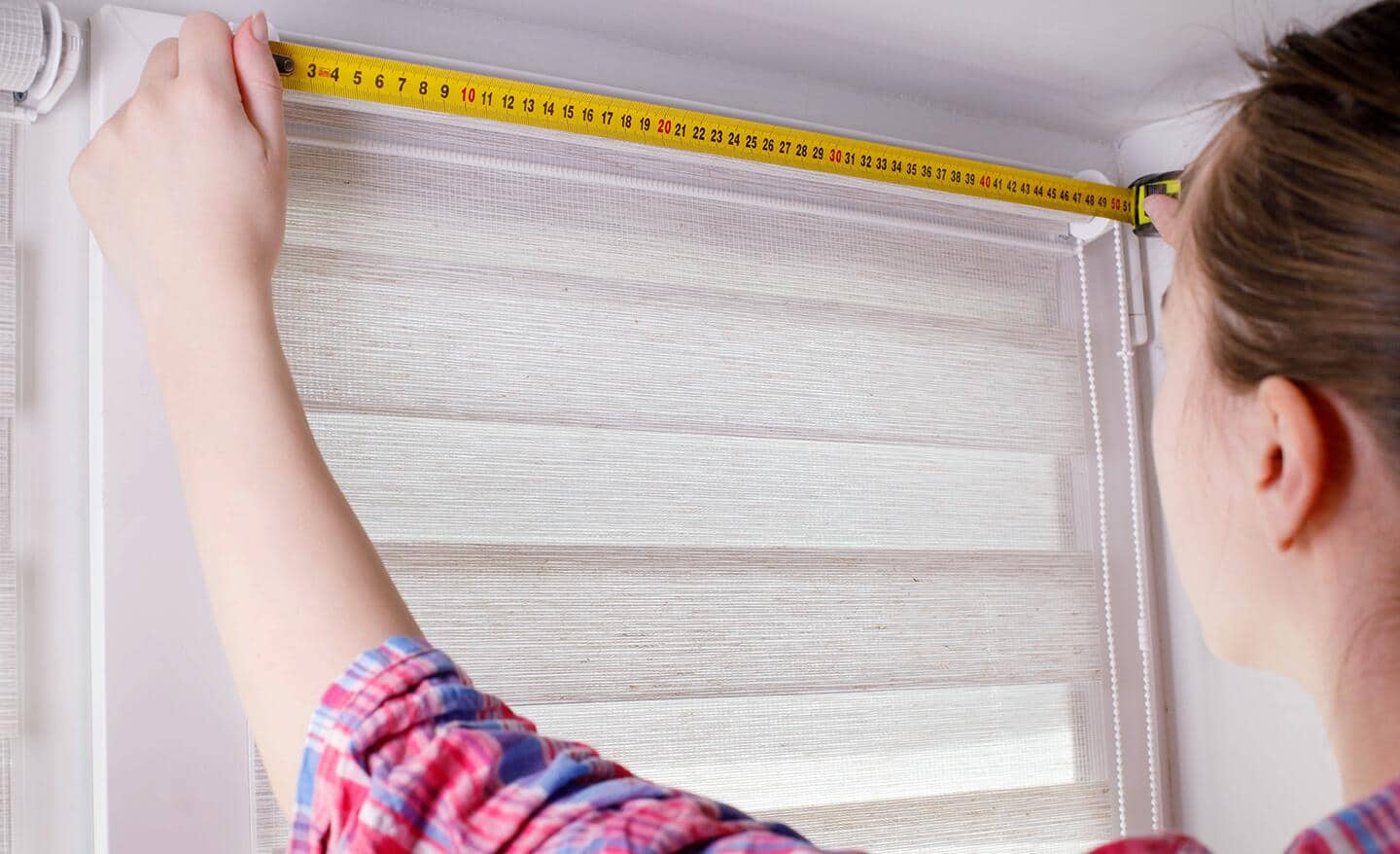 Pencil marks on window trim with a small level held against the marks to ensure bracket placement is level