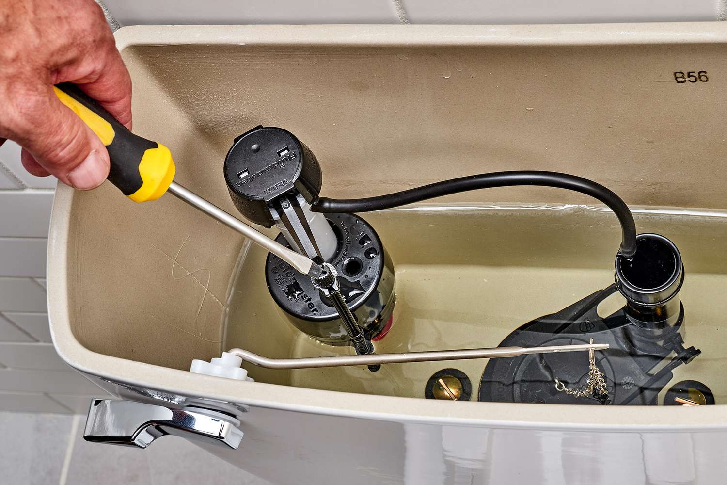Photo of an open toilet tank showing the fill valve and refill tube connected to the overflow pipe