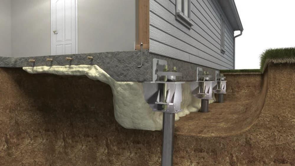 Residential concrete patio slab with several small drilled holes laid out in a pattern for slab lifting injection